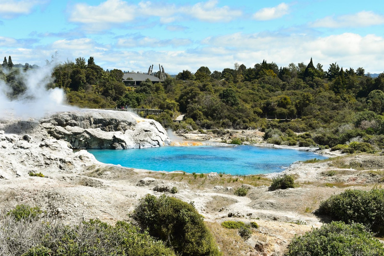 Vivid blue geothermal pool surrounded by steam