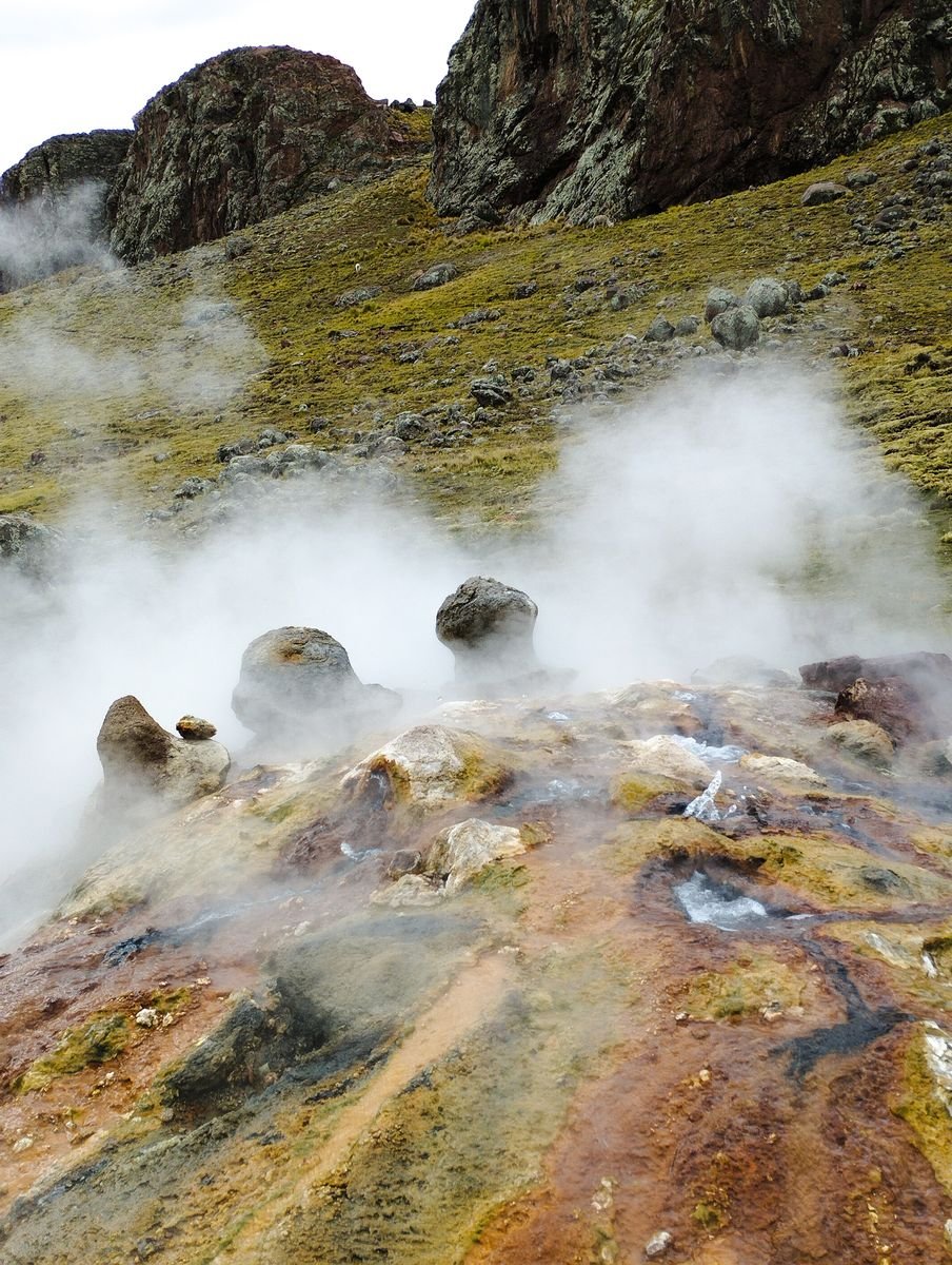 Steam rising from a geothermal hot spring landscape