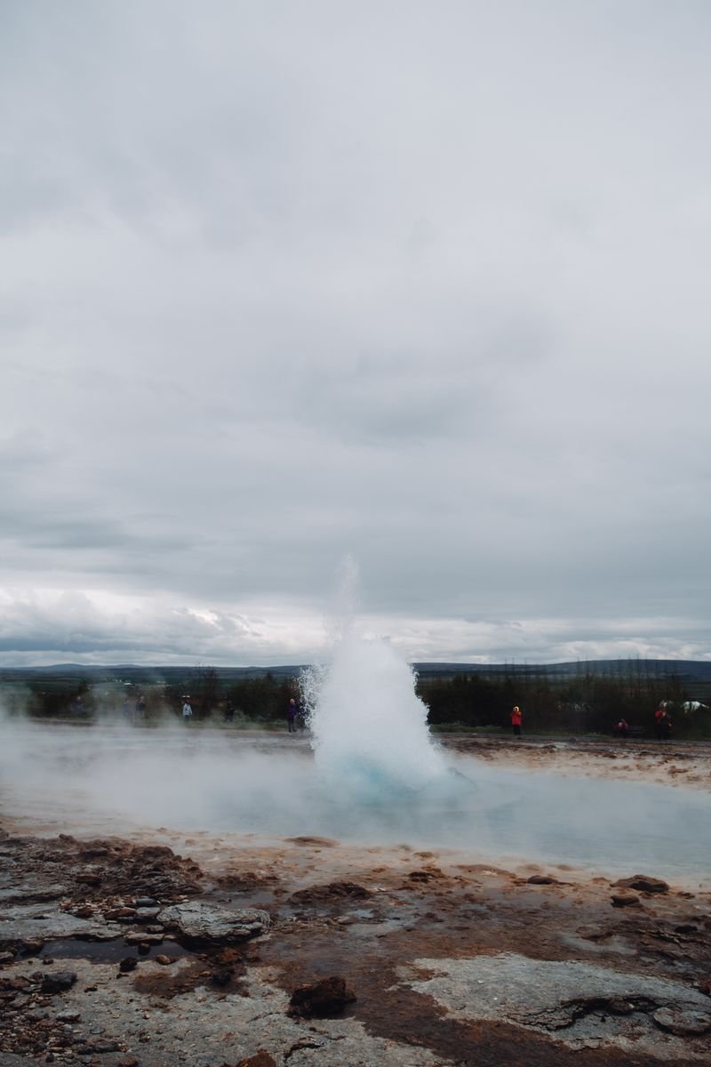A geyser erupting in a rocky landscape