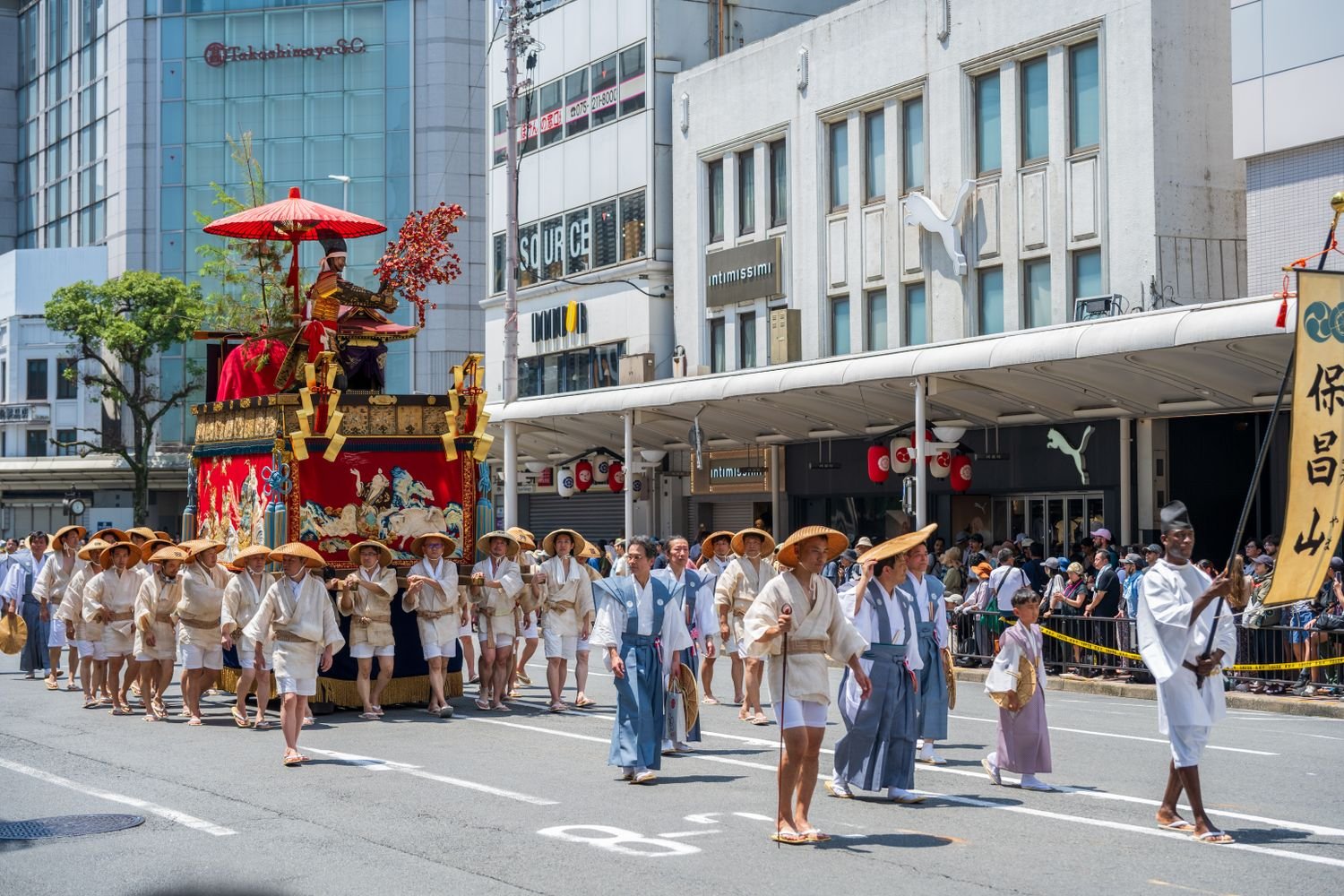 Performers in traditional Japanese dress marching in a Kyoto festival procession