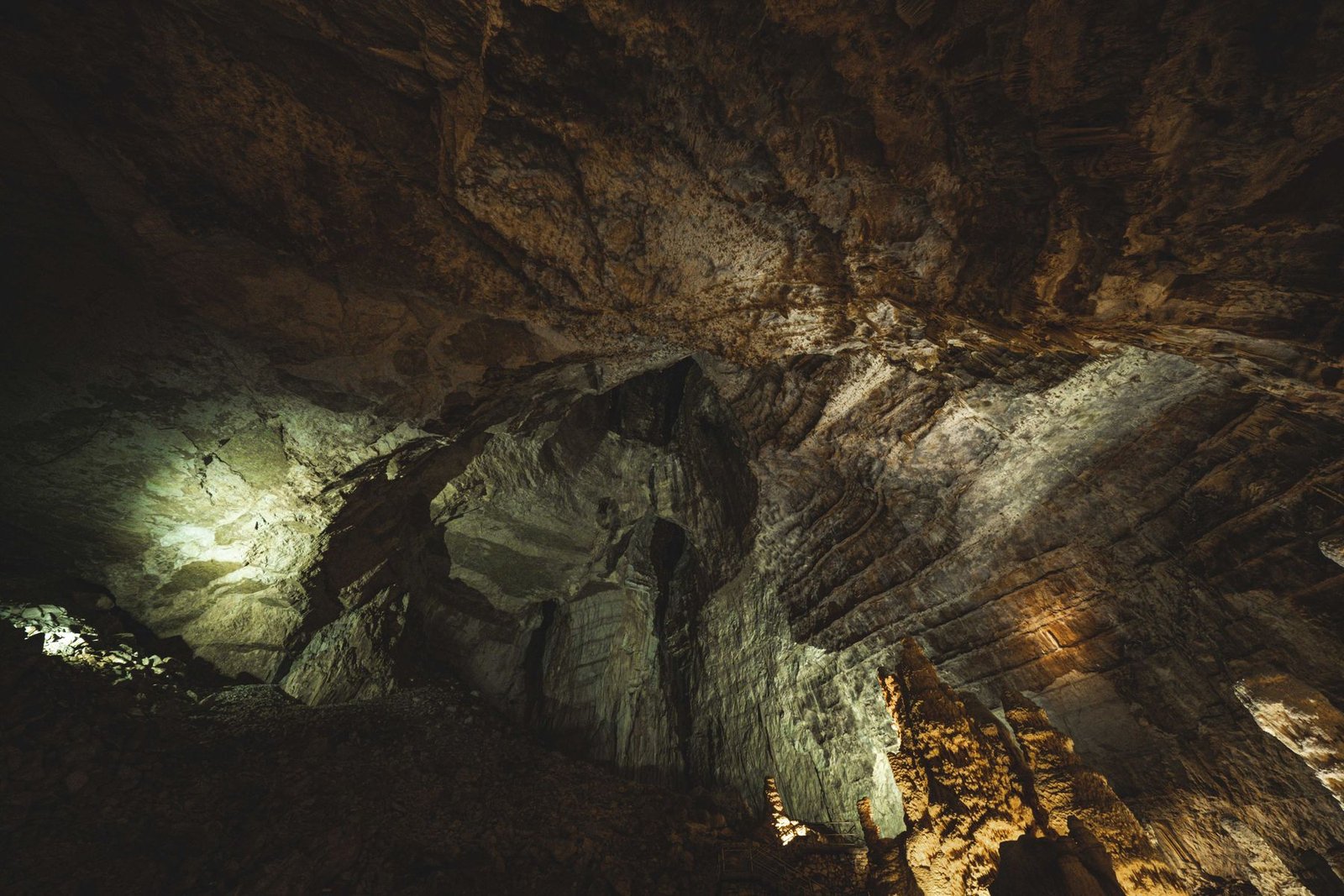Dimly lit interior of a vast underground stone cavern