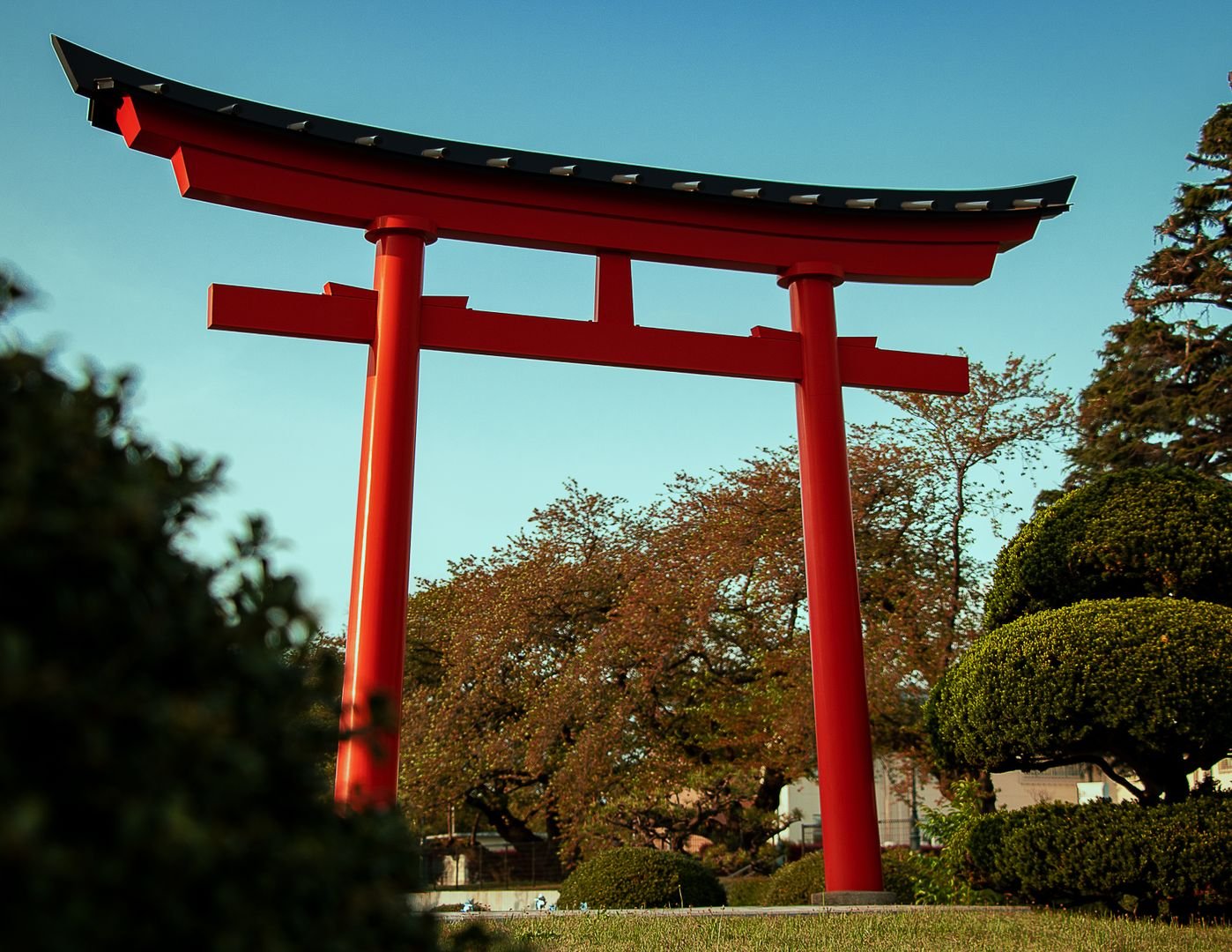 Red torii gate at a Japanese shrine surrounded by greenery