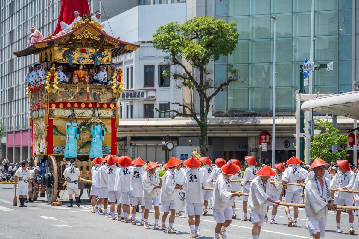 Traditional wooden festival float being pulled through a Kyoto street