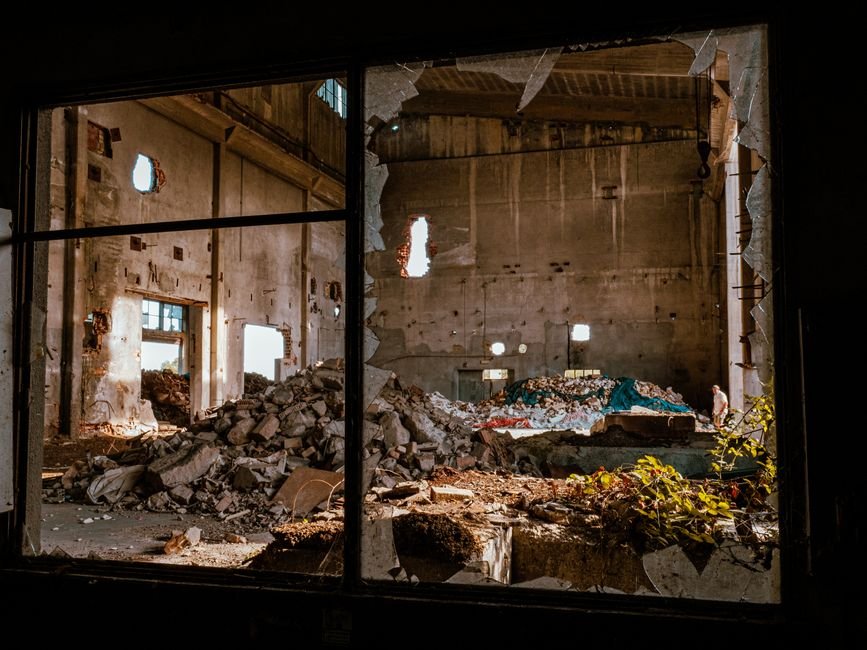 Sunlight streaming into an abandoned concrete interior, evocative of Gunkanjima's ruined apartment blocks