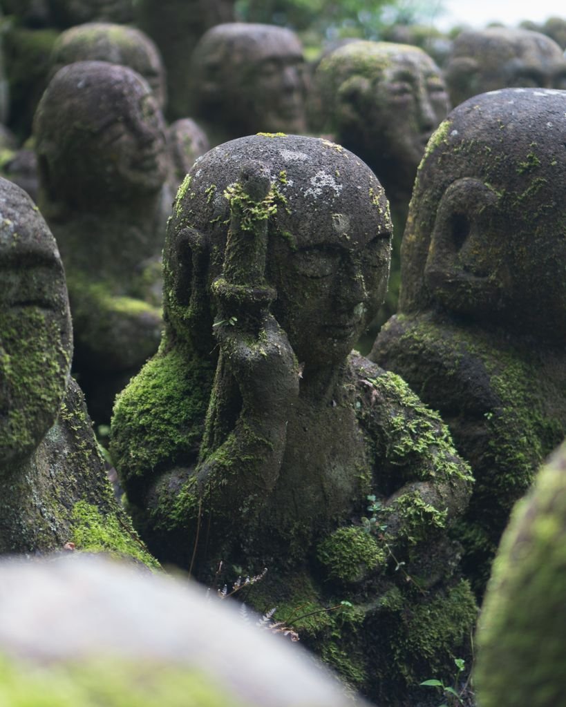 Ancient moss-covered stone statues at a Japanese temple