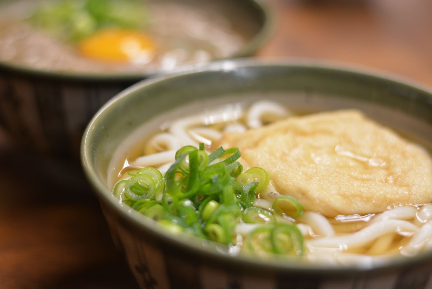Steaming bowl of Japanese udon noodle soup with toppings