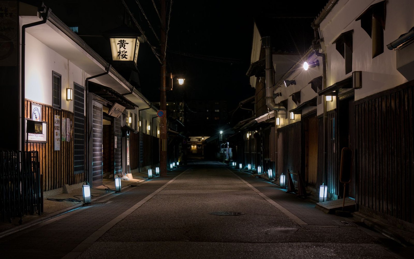 A quiet lantern-lit alley at night in Kyoto, similar to the atmosphere of Kurama village during the fire festival