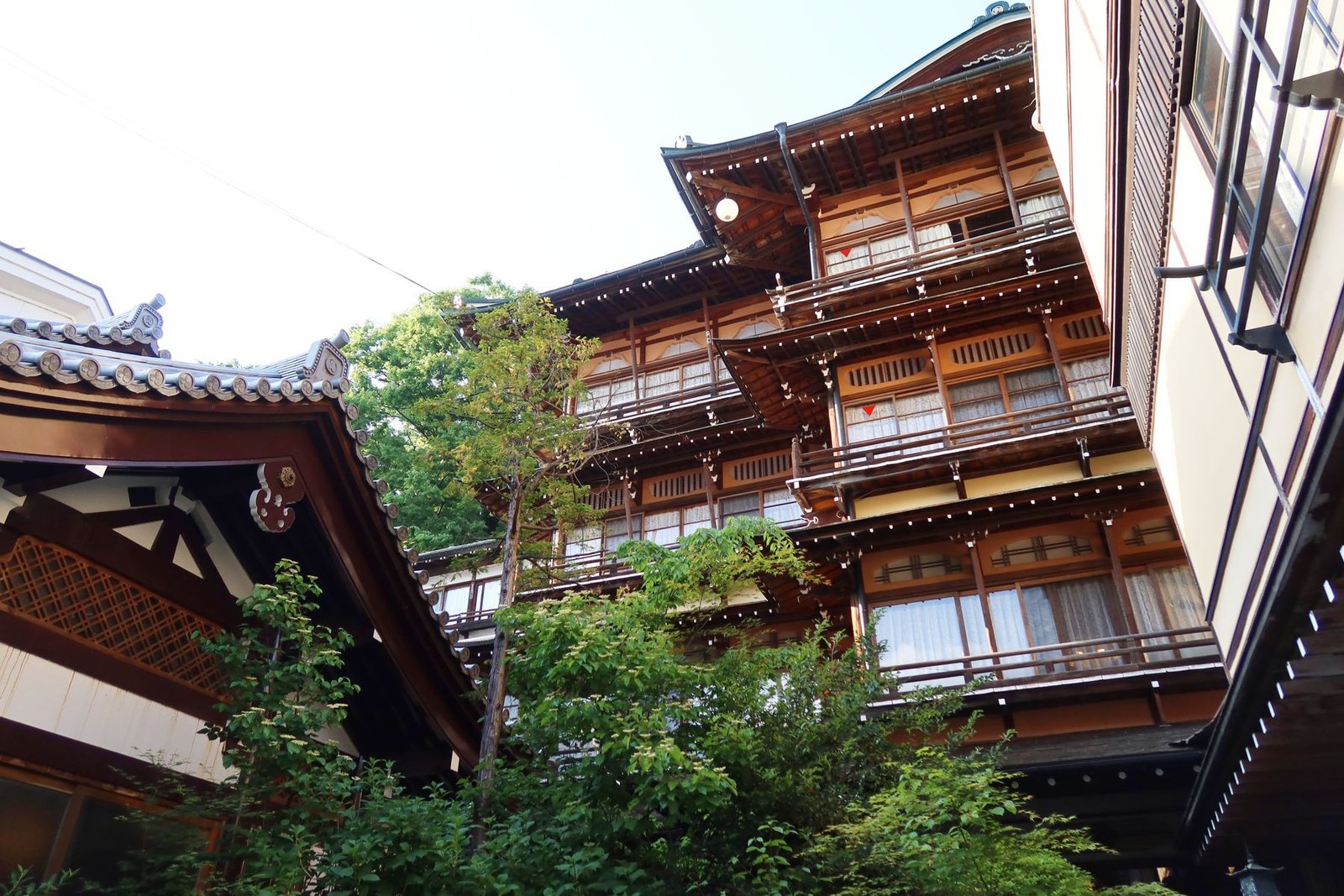Wooden architecture of a traditional ryokan amidst greenery in Japan
