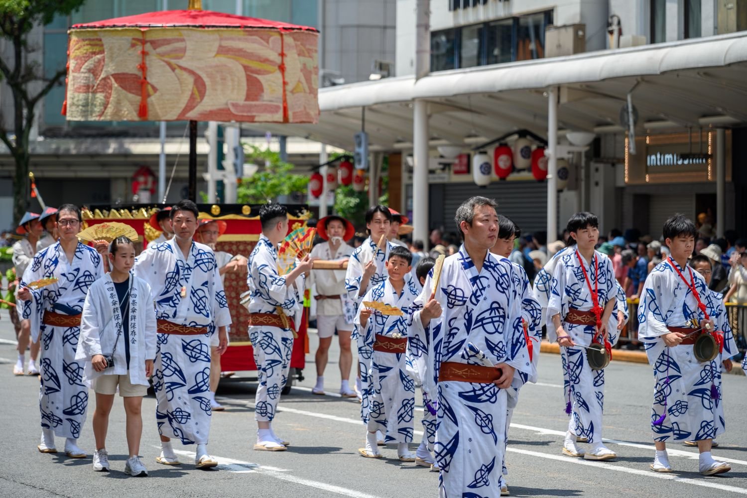Festival participants in traditional attire parading through the streets at night, similar to haneto dancers at Nebuta Matsuri