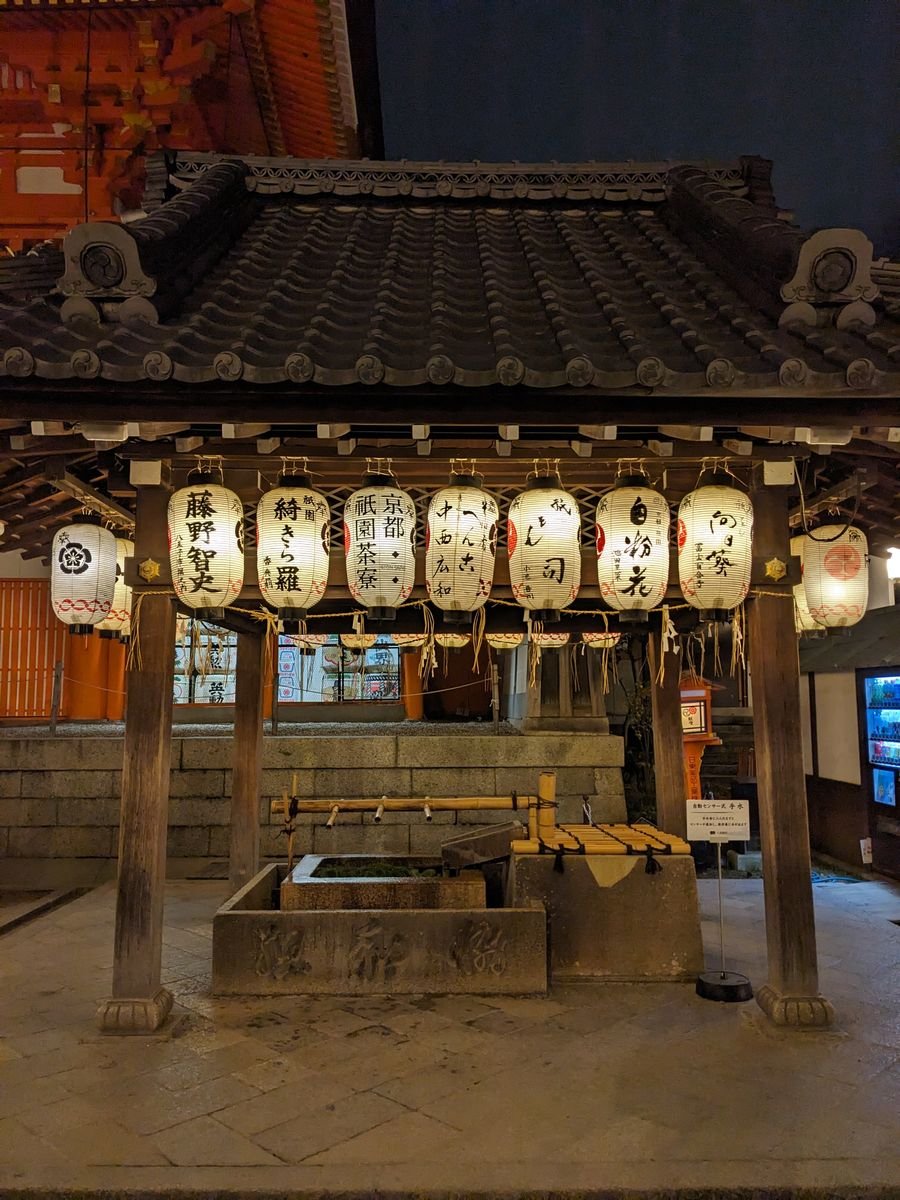 Traditional lanterns illuminating a shrine hall at night in Japan