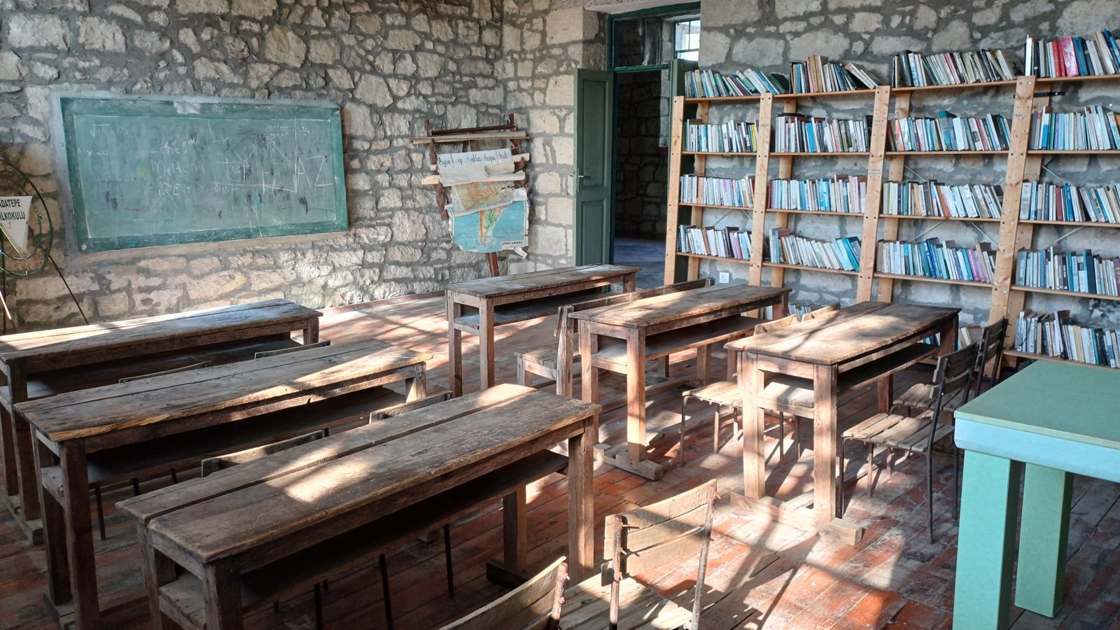An empty vintage classroom with wooden desks and a chalkboard, evoking nostalgia