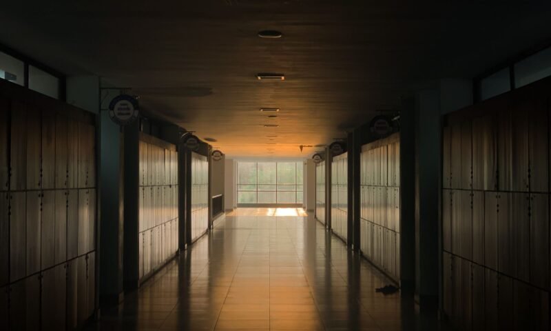 Sunlit empty Japanese-style school corridor with lockers