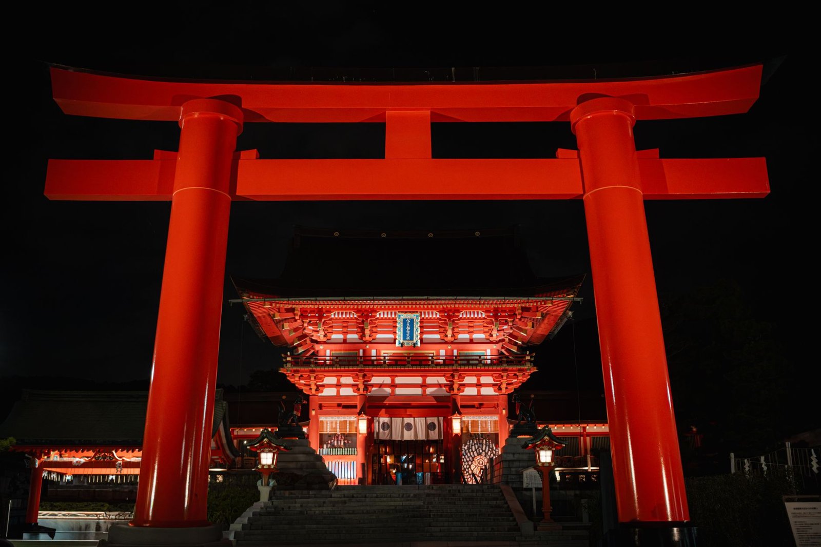 Illuminated red torii gate at a Japanese shrine at night