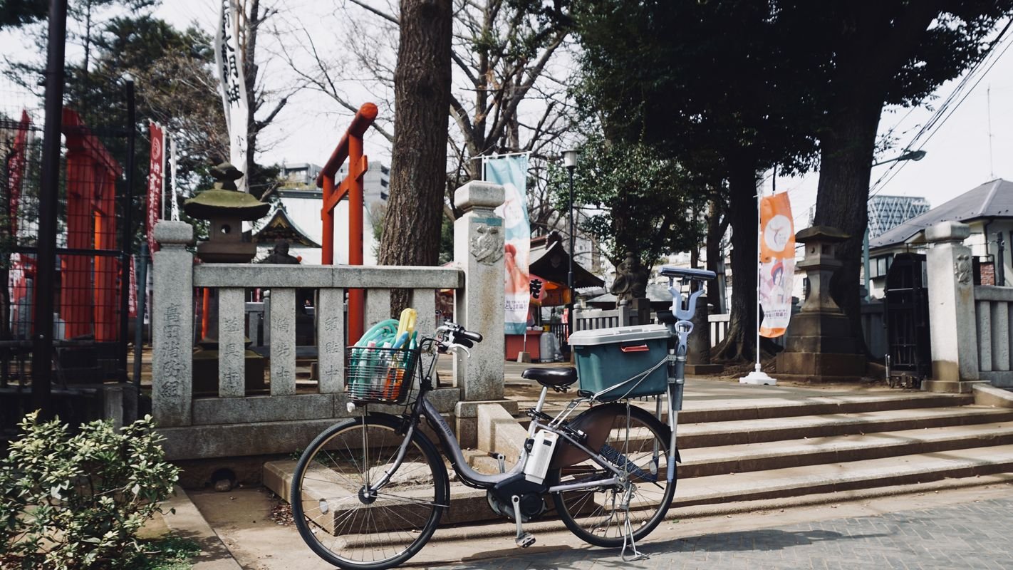A quiet Japanese shrine entrance along an ordinary Tokyo street