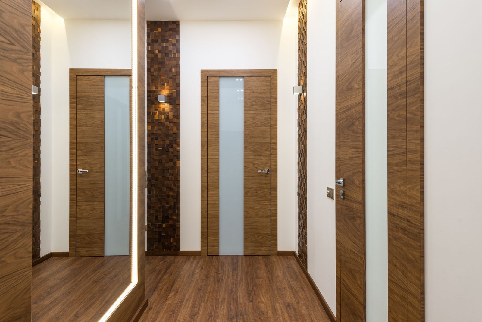 A hallway lined with closed doors and a mirror