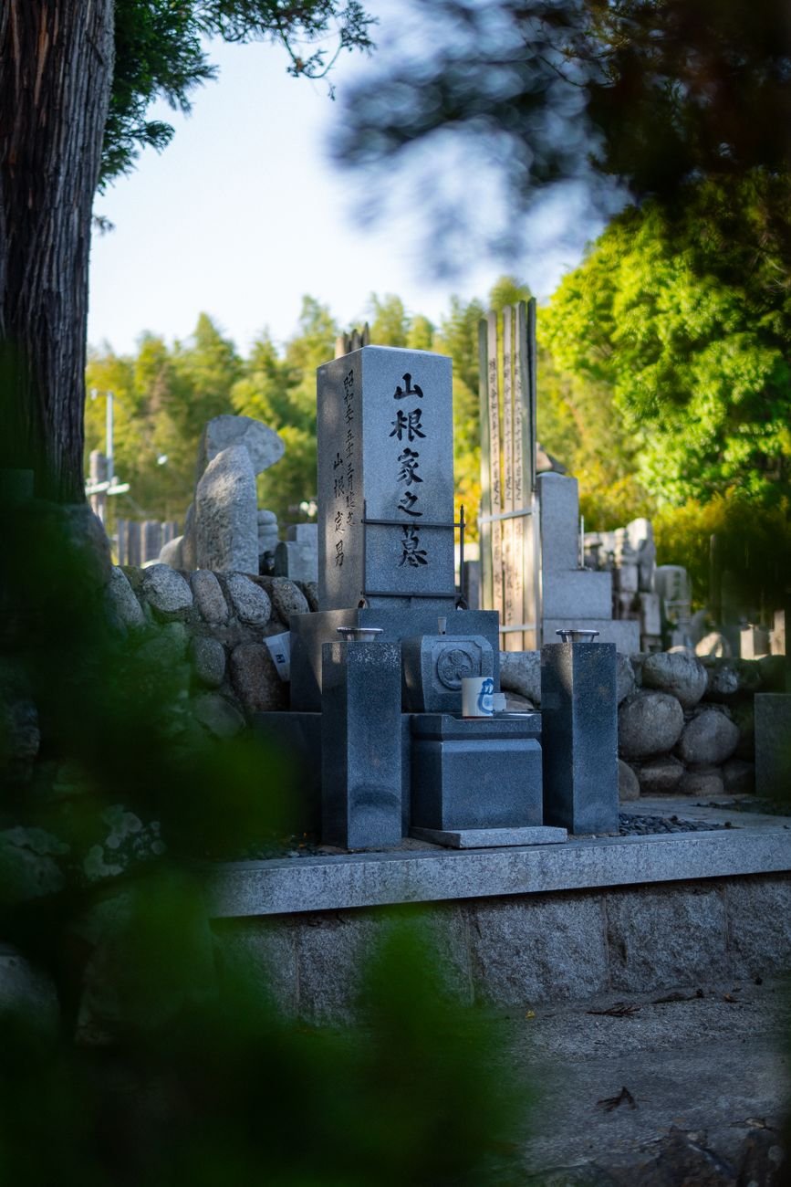 Rows of traditional stone grave monuments in a peaceful Japanese cemetery