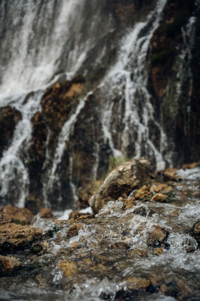 Waterfall cascading over dark rock in a forest gorge