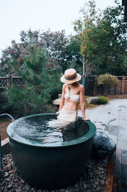Woman soaking in an outdoor Japanese hot spring bath