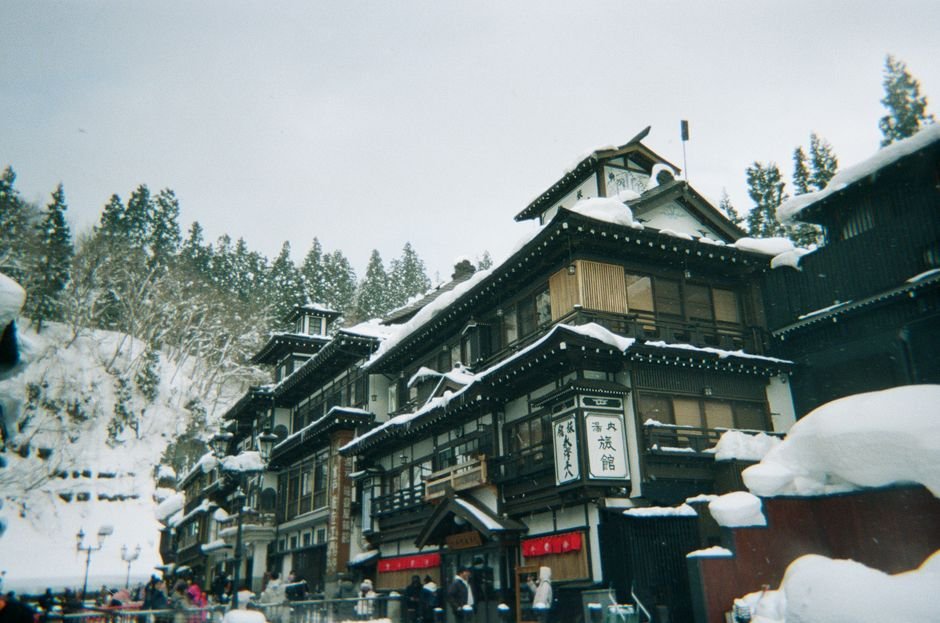 Historic Japanese hot spring town with steam rising between traditional buildings