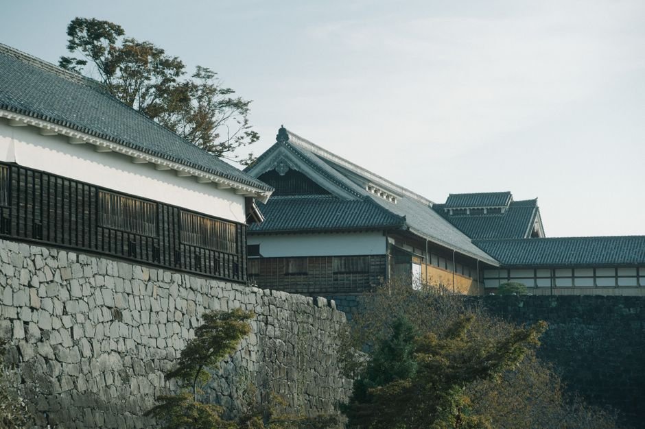 Traditional Japanese castle with stone walls, similar to Tsuruga Castle below Mount Iimori