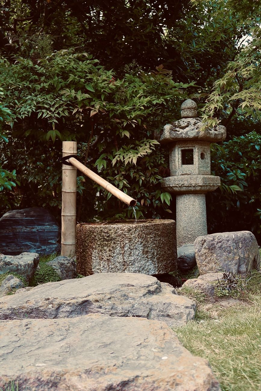 Old stone well in a shaded Japanese temple garden