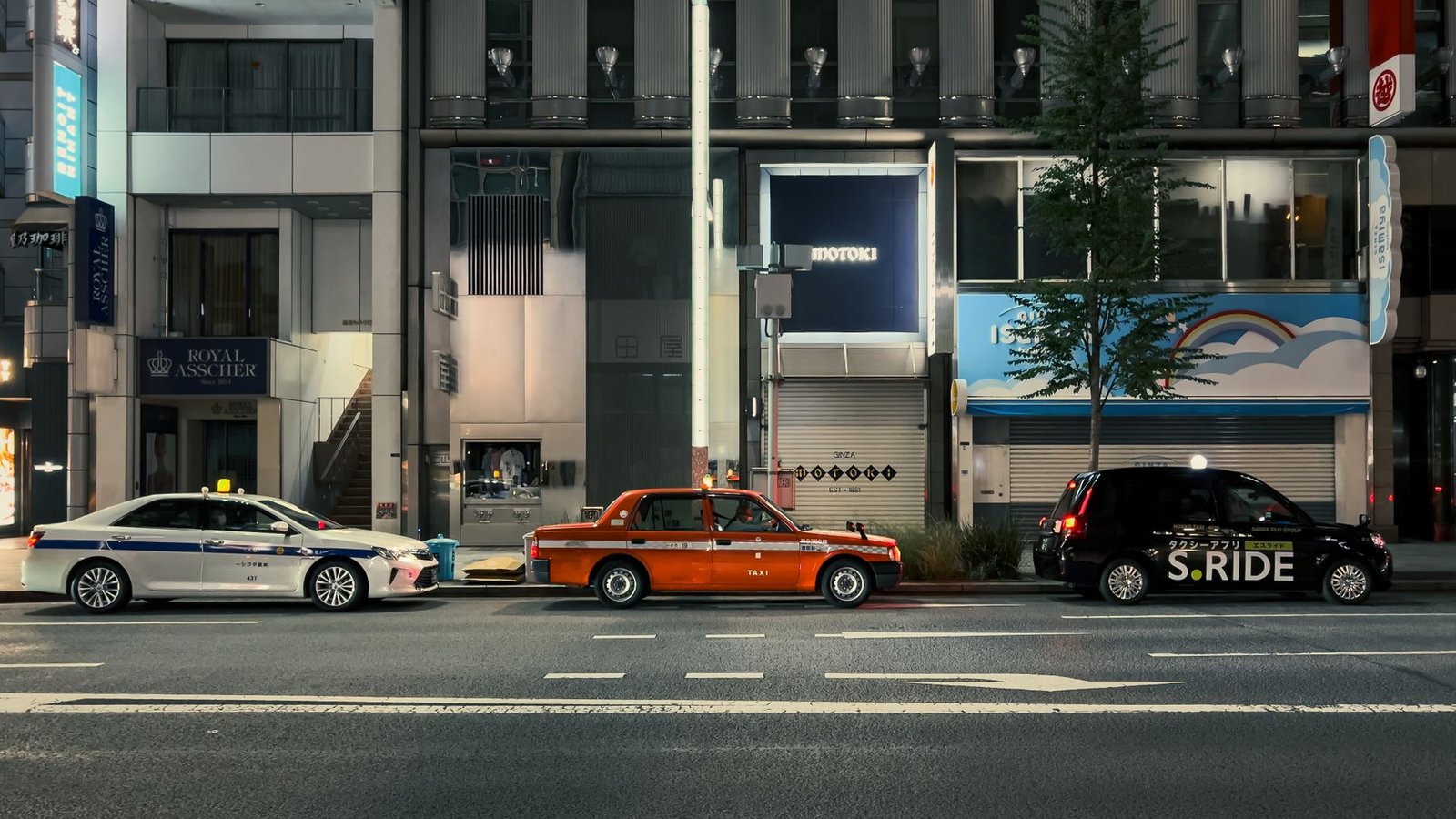 Taxis lined up on a quiet Tokyo street at night