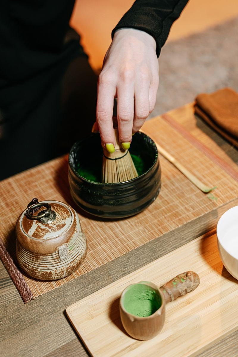 Hand whisking matcha in a bowl during a Japanese tea ceremony